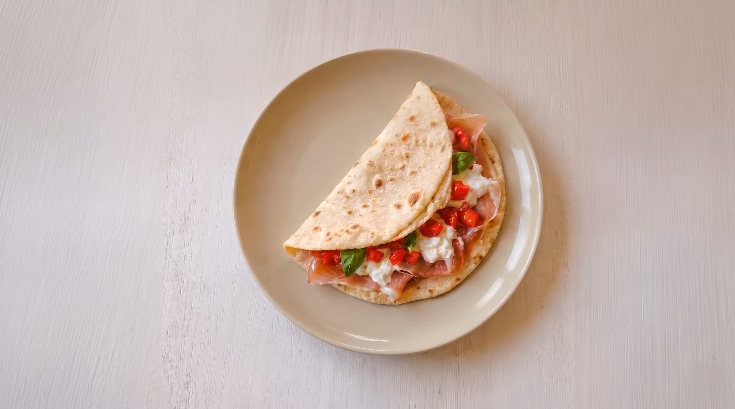 Piadina con prosciutto di Parma DOP, burrata pugliese, pomodorini freschi e basilico
