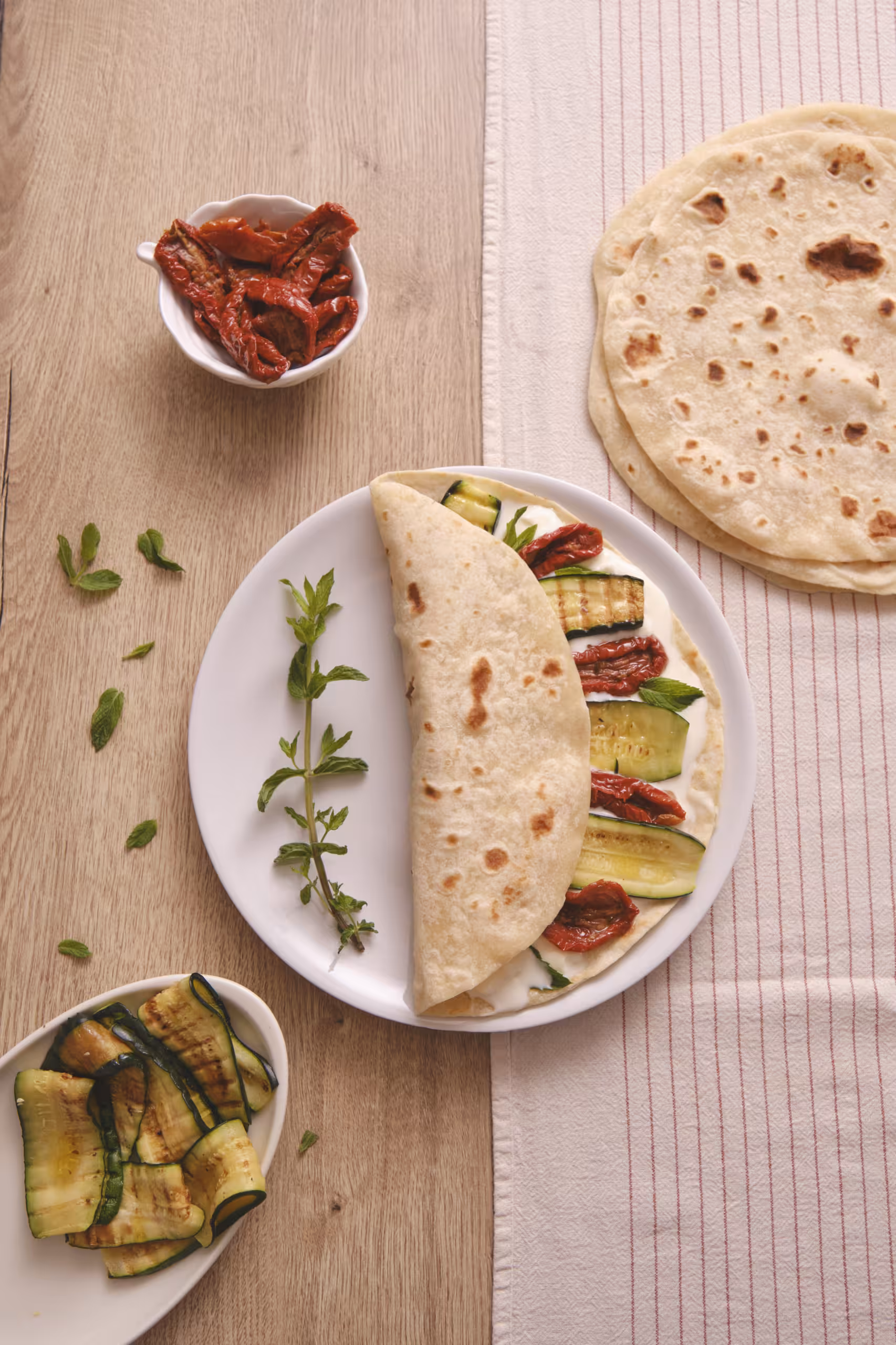 Piadina Romagnola con squacquerone, zucchine grigliate, pomodorini secchi e menta: freschezza e tradizione!